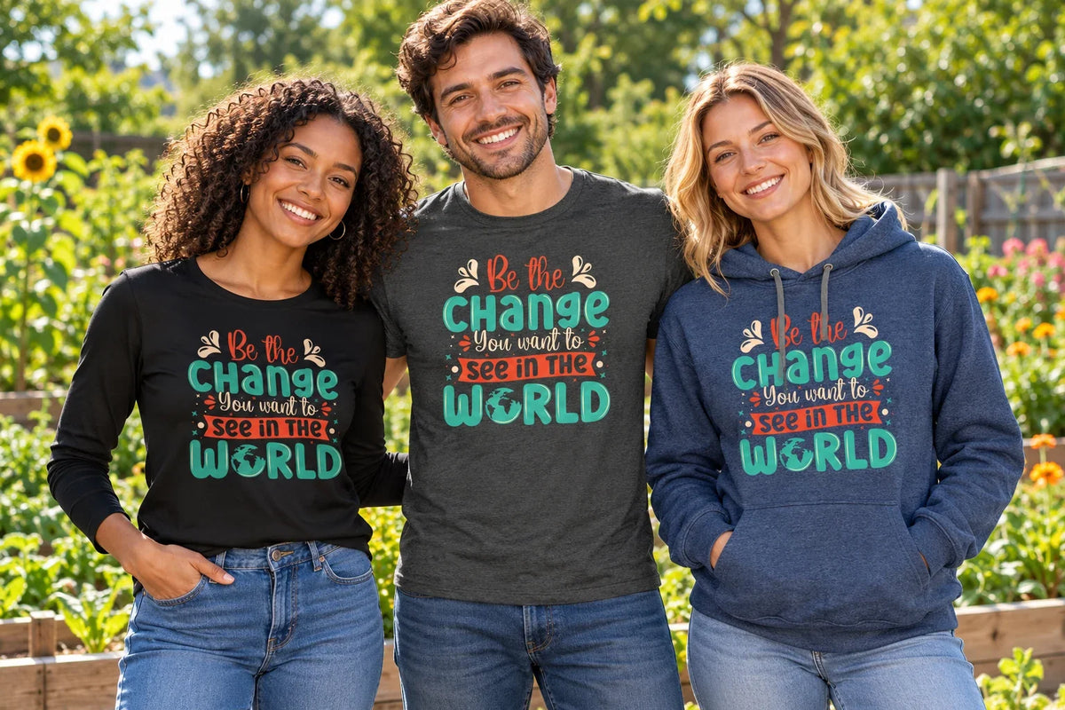 Three friends wearing Be The Change You Want To See In The World shirts and an indigo hoodie in a sunny garden.