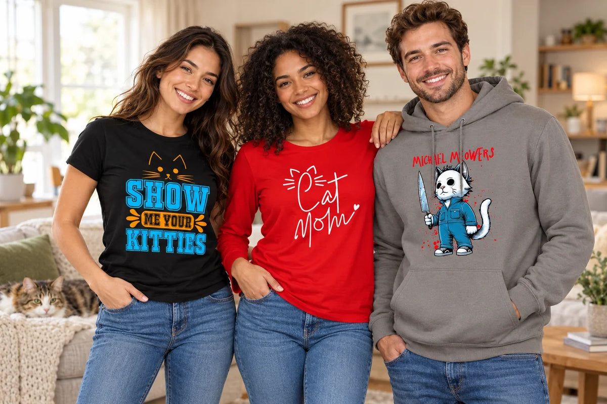 Three adults wearing Cats shirts and a hoodie with Show Me Your Kitties, Cat Mom, and Michael Meowers designs in a cozy living room.